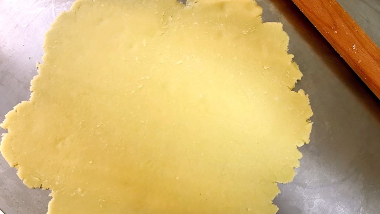 蜜豆奶酪派,冷藏好的派皮擀成比派盘大一些的薄片。