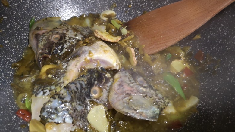 酸菜鱼🐠,锅中起油，葱爆香，放入腌菜翻炒，加入鱼头翻炒2分