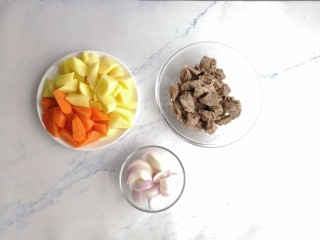 红酒土豆炖牛腩,胡萝卜切块，牛腩放入锅里，加入葱、姜、料酒焯水去除血沫后洗净。