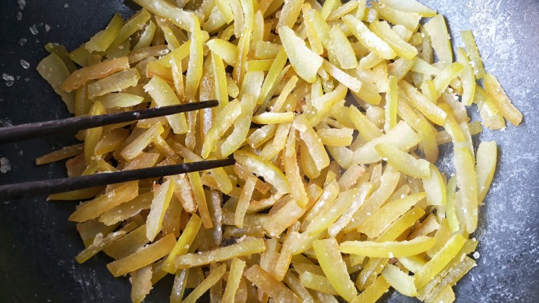 柚子皮糖,倒入挤干水的柚子皮中大火用筷子快速翻炒至吸干所有冰糖浆。