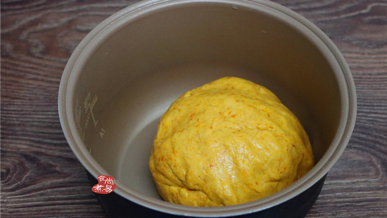 发面免油煎南瓜饼,将面粉和南瓜泥揉成光滑柔软的面团，遮上保鲜膜或干净的湿毛巾，放在温暖处发酵30分钟左右。