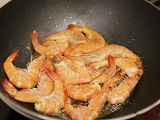 鲜虾粉丝煲,把所有的整虾和下身放入锅中煸炒至变色。