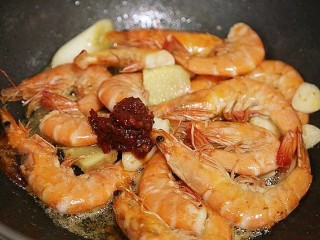 鲜虾粉丝煲,将葱段，姜片，蒜片放入锅中煸炒出香味。再往锅中放入一勺郫县豆瓣儿酱，煸炒出红油。