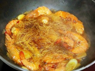 鲜虾粉丝煲,把泡好的粉丝切短一点儿，放入锅中。再放入两勺蒸鱼豉油，少许盐，半勺白糖调味。