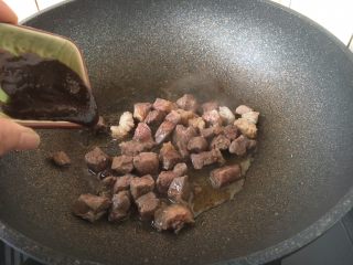 黑胡椒牛肉粒,倒入1勺的黑胡椒酱并翻炒均匀。