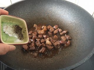 黑胡椒牛肉粒,用手撒入现磨黑胡椒碎和现磨海盐，翻炒均匀。 黑胡椒碎和盐的量依个人口味撒入。 撒黑胡椒碎时一定用手撒，且要撒的均匀些。