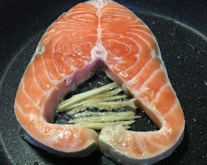 煎鮭鱼,待鮭鱼煎出油时，放入姜丝