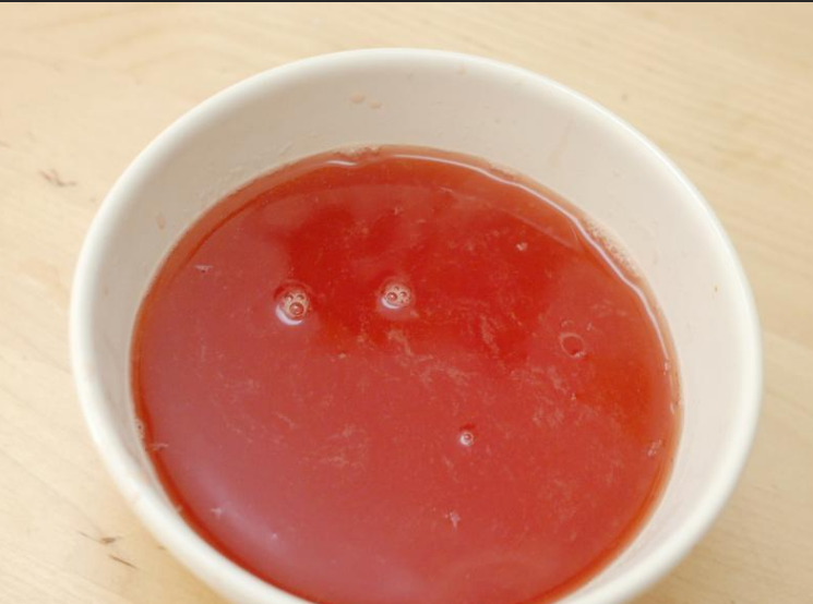 自制草莓柠檬水,将草莓糖浆用筛过滤，待凉备用