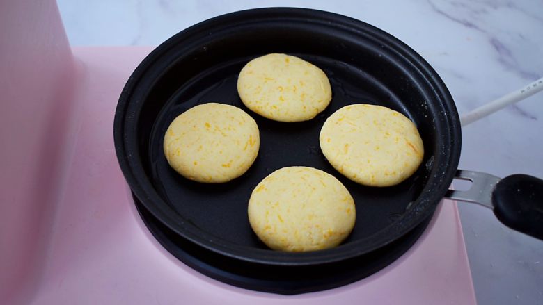无糖版南瓜饼,平底锅刷一层薄薄的食用油，再放入南瓜生胚，小火慢煎至表面金黄色