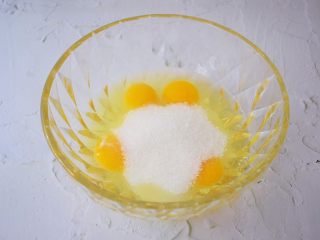 柠檬玛德琳蛋糕,鸡蛋打入容器中，一次性加入全部的白糖，用手动打蛋器搅拌至白糖融化