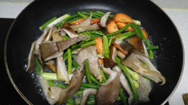 蒜苗炒蒜苔、胡萝卜、平菇,加入适量水，炒至蒜苔断生。