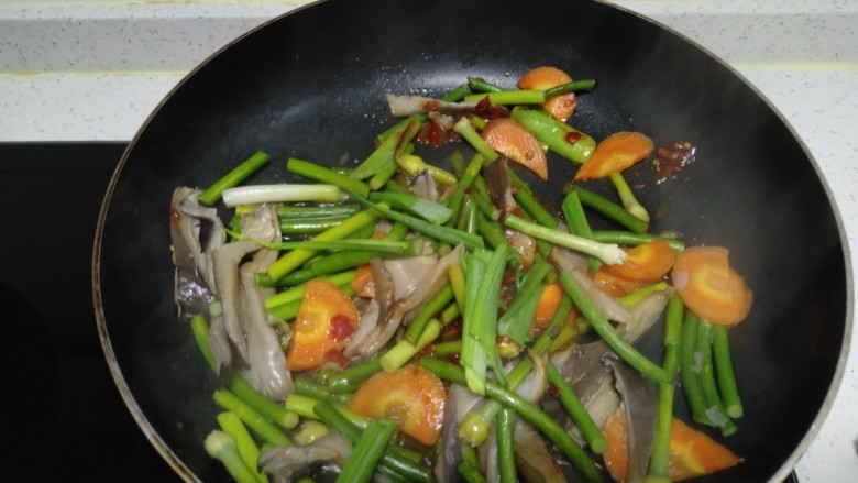 蒜苗炒蒜苔、胡萝卜、平菇,翻炒均匀。
