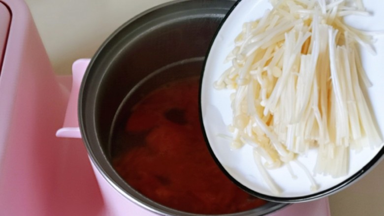 味道鲜美的茄汁肥牛卷,炒好的番茄倒入汤锅中，加入纯净水，再加入金针菇，调为最大档烧开煮2分钟。