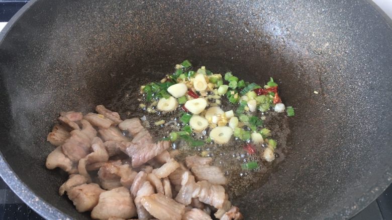 肉片炒黑鸡枞,将肉片扒在锅的一边（盛出备用也可以），爆香葱姜蒜辣椒。