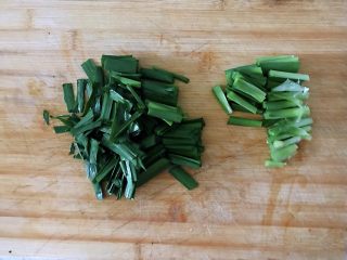韭菜胡萝卜炒豆芽,清洗干净的韭菜根部和叶子分开切。