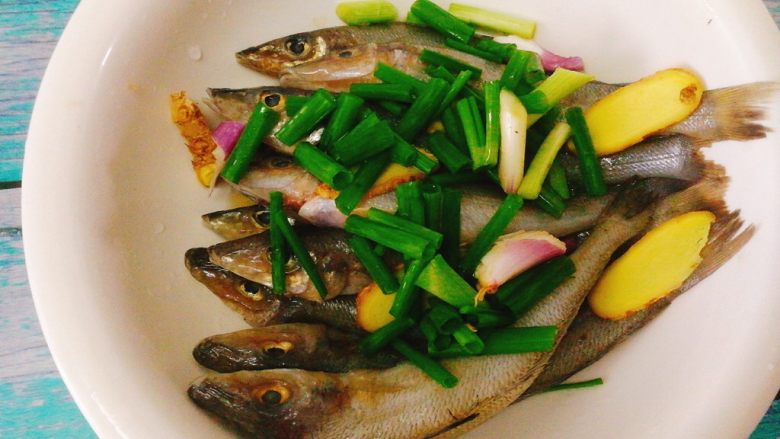 香酥沙丁鱼,将鱼放入一个大碗里，依次加入香葱，姜片。
 