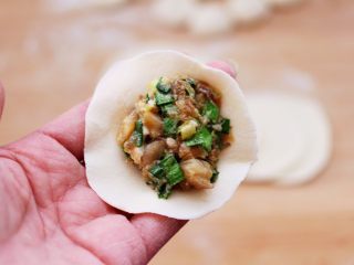 蘑菇韭菜饺子,擀好的面皮放入适量的馅料。