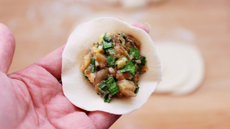 蘑菇韭菜饺子,擀好的面皮放入适量的馅料。