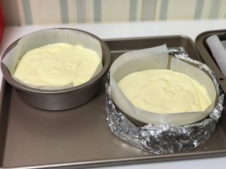  舒芙蕾芝士蛋糕,将拌好的芝士糊倒入铺了油纸的模具里，放入烤盘，烤盘里面注入热水。