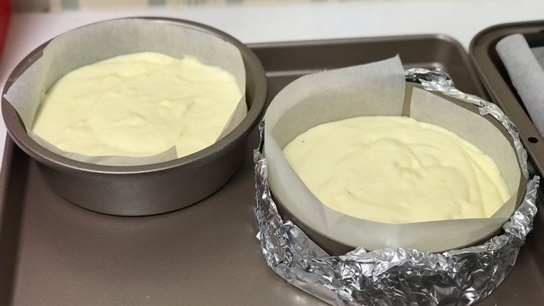  舒芙蕾芝士蛋糕,将拌好的芝士糊倒入铺了油纸的模具里，放入烤盘，烤盘里面注入热水。