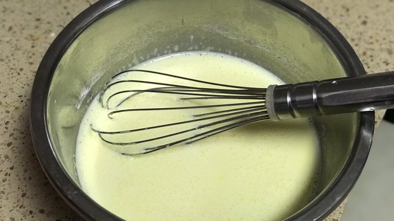  舒芙蕾芝士蛋糕,将牛奶倒入蛋黄中不断搅拌至完全融合。