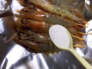 盐烤大虾,插好竹签的大虾放在锡纸上，撒盐