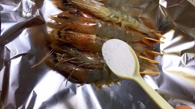 盐烤大虾,插好竹签的大虾放在锡纸上，撒盐