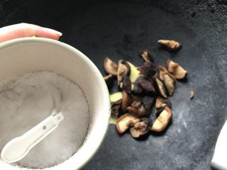 竹荪冬菇鸡汤,向锅里加入姜片、冬菇和盐煸炒煸出水分。