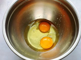菠菜鸡蛋饼,碗里敲入2个鸡蛋，用筷子顺着一个方向打散。