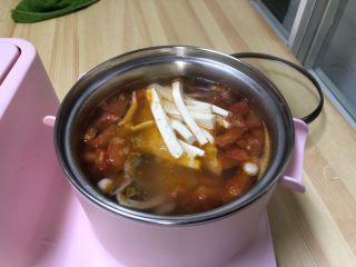 番茄豆腐菌菇汤,炒好后的番茄倒入锅中，菌菇也倒入煮锅中加入一大碗水。