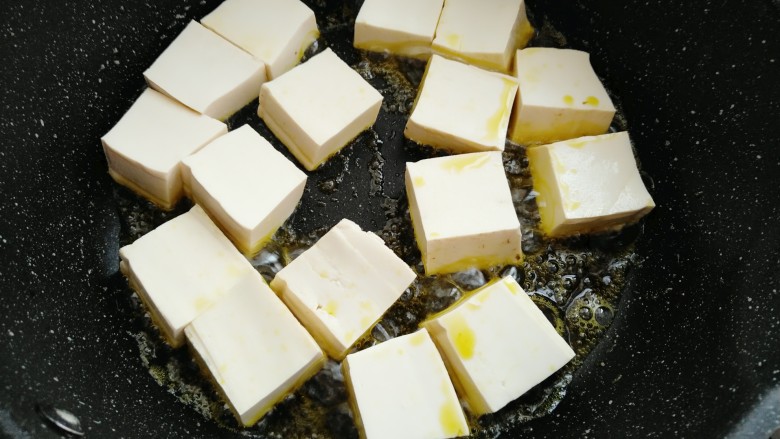 香菇焖豆腐,热锅烧油放入豆腐中大火煎制一分钟