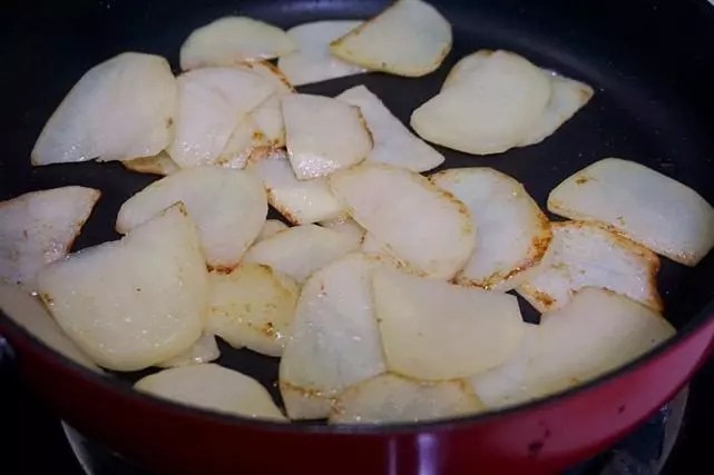 干锅鸡翅,接下来利用刚才剩余的鸡翅的油脂，继续用来煎土豆片，土豆比较吃油，又容易粘锅，所以要勤翻动，觉得太粘了，可以加入适量食用油。