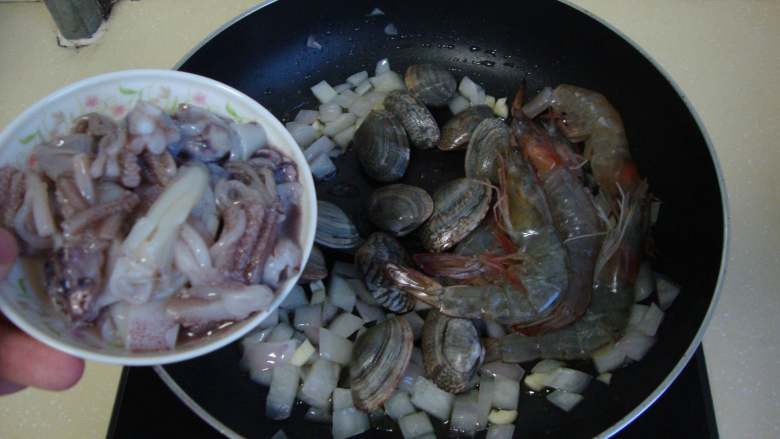 墨汁意面,放入海鲜炒匀，盖上锅盖焖至蛤蜊开口