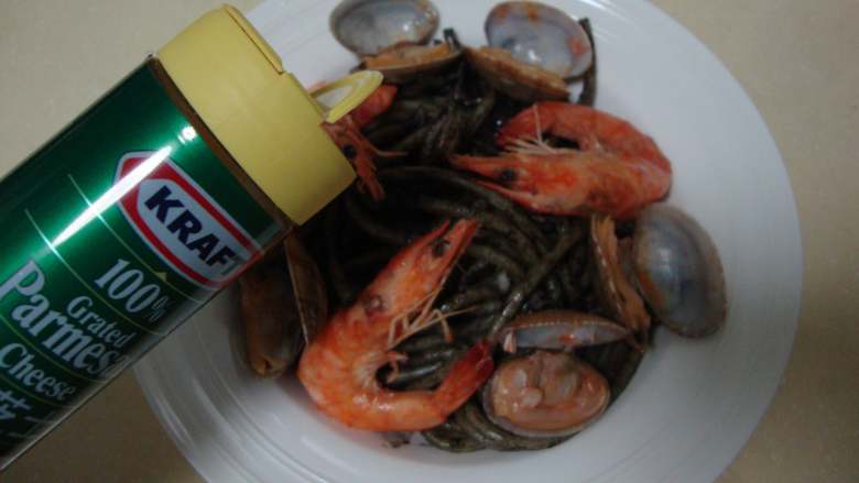 墨汁意面,装盘，摆上之前取出来的虾和蛤蜊，撒芝士粉