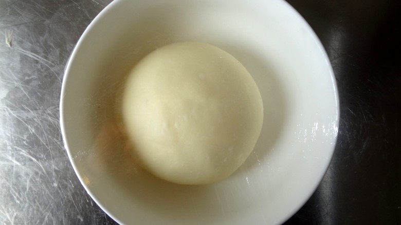   花式芝士肠仔包,整理成光滑的面团放入碗中盖上保鲜膜