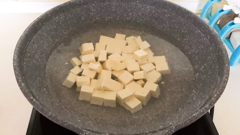 麻婆豆腐盖浇饭,先把北豆腐切成小块，锅里加入冷水，水开后加入豆腐块，焯水3分钟