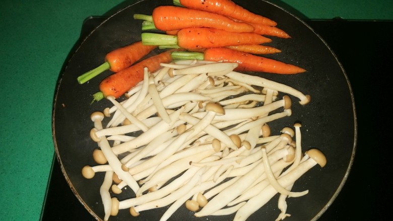 香煎手指萝卜,待手指萝卜半熟时，推到一边，放入姬菇，翻炒至变软，再次加适量胡椒粉