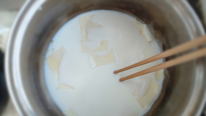 芒果牛奶冻,开小火，用筷子搅拌至吉利丁片完全融化后关火凉凉