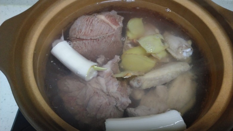 酱羊肉、牛肉、鸡翅炖土豆粉,砂锅中加入摸过肉的开水，加入葱段。