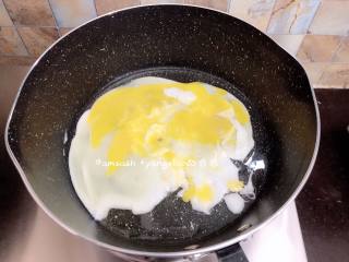 三丝春卷,锅中注入食用油，加热，磕两个鸡蛋，煎成鸡蛋饼，煎好倒在粘板上，切成丝