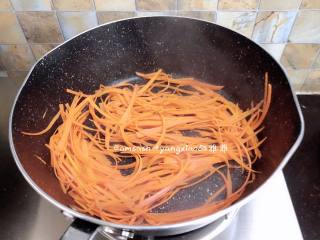 三丝春卷,胡萝卜切成丝，锅中注入适量的油，把胡萝卜炒至断生，加入一丢丢的盐，盛出晾凉备用