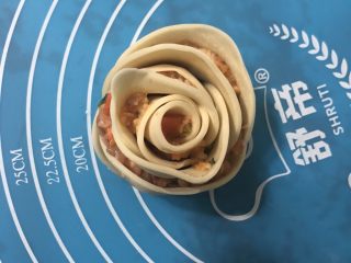玫瑰花🌹饺子,从一端慢慢卷起，就能卷成如图的玫瑰花形状，重合处用点水粘一下。