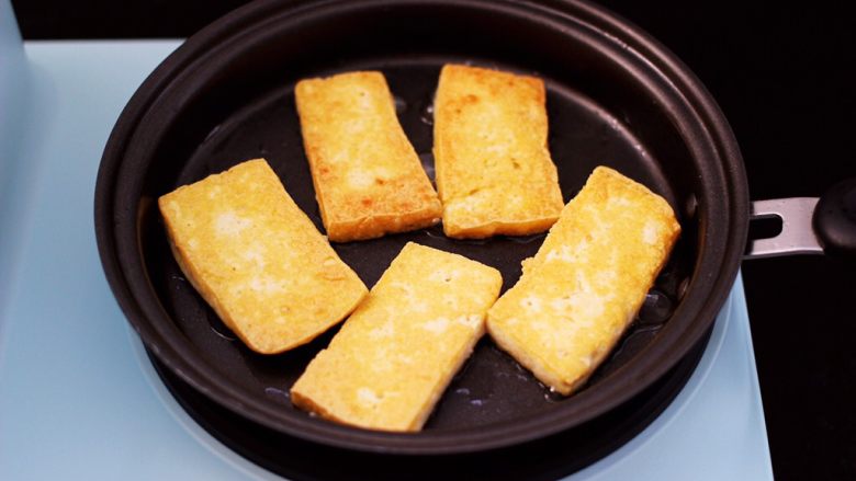 香辣煎豆腐,中小档将豆腐煎至金黄，再翻一面，两面都煎至成金黄色。