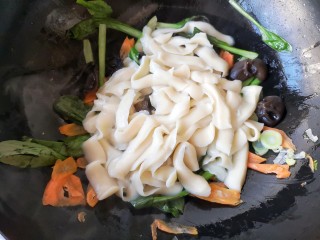 时蔬炒刀削面,将煮好的刀削面放在菜上。