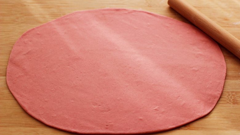 蒜香粉嫩肉龙花卷,用擀面杖擀成薄面皮。