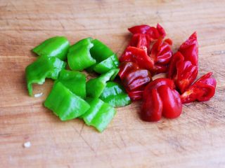 时蔬美味牛肉串,这个时候把青尖椒和红椒，用刀切成小块。