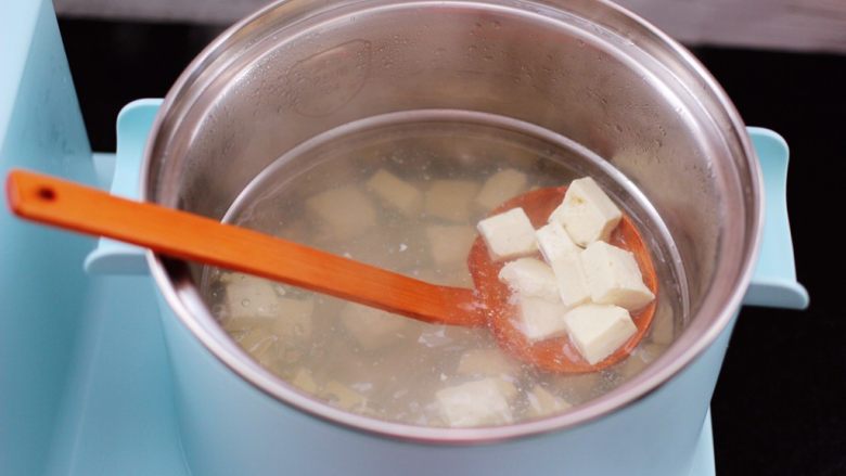 虾皮翡翠白玉羹,东菱早餐机的汤锅里，加入适量的清水烧热后，放入豆腐焯水后，捞出沥干水分备用。