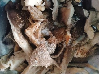 比肉还好吃的干炸蘑菇,把挤干水份的蘑菇放在盆里加适量食盐和五香粉和胡椒粉；