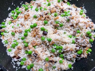 豌豆饭,倒入浸泡好的米，一直翻炒，把剩下的汤汁炒干为止，炒好以后，把米饭倒入木桶里。