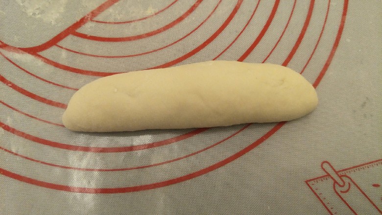 蒜香香肠热狗面包,从上往下搓回来。整形成纺锥体，封口朝下。开始第二次发酵到两倍大。